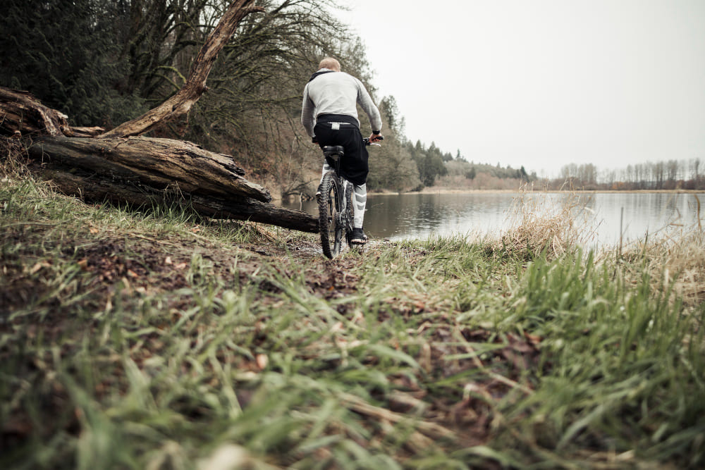 Iemand fietst door een bos richting een meer
